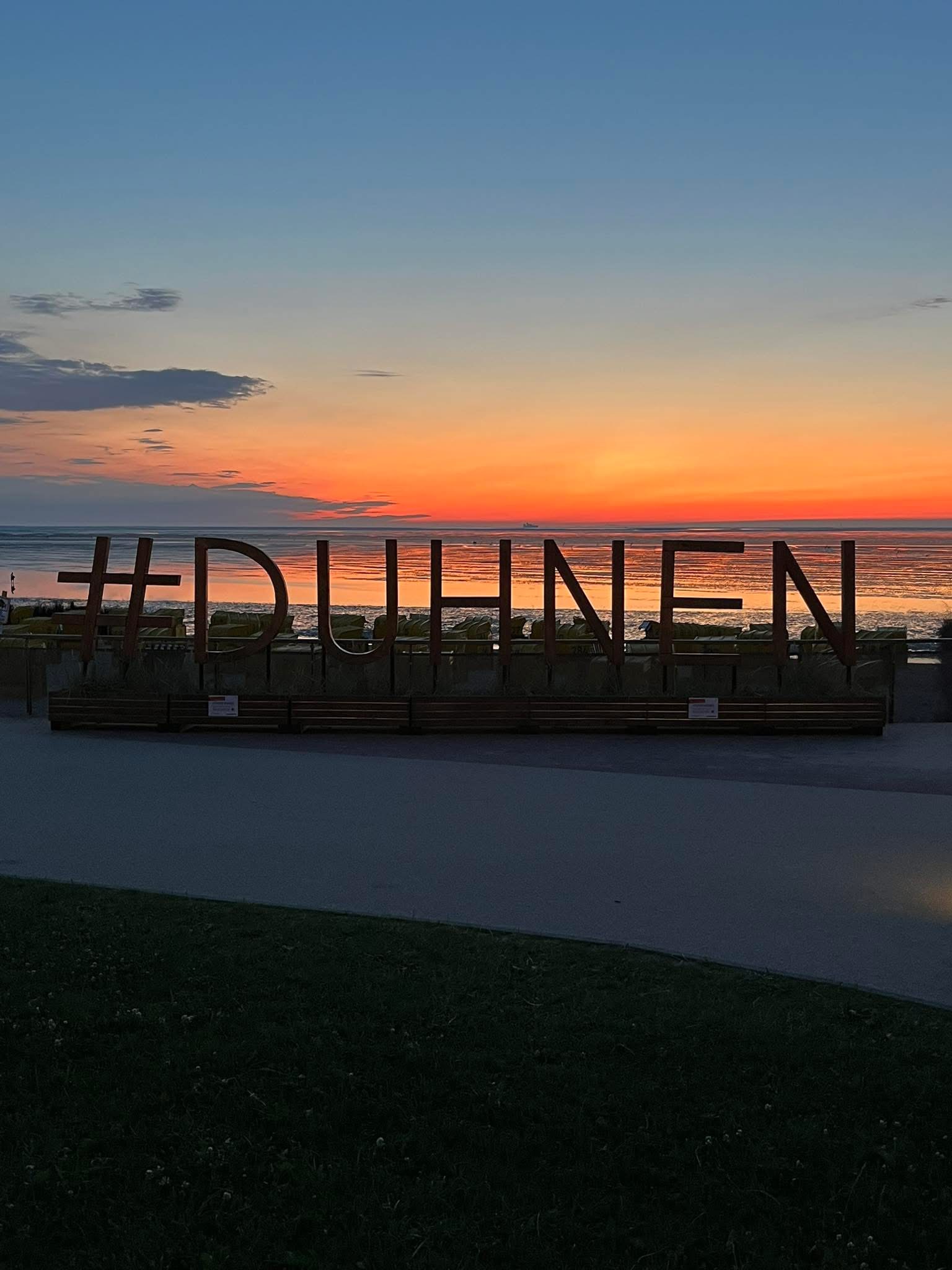 Duhnen-Schriftzug am Nordseestrand im Sonnenuntergang